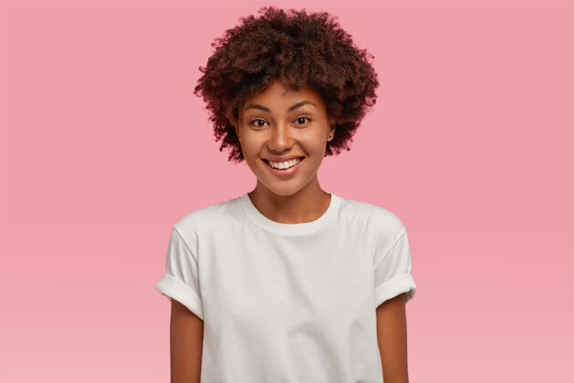 看迷人的非洲裔美国年轻女子 带着牙齿般温柔的微笑 露出洁白的牙齿 穿着休闲的模拟t恤思考种族高兴