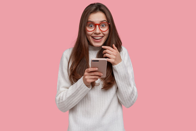 使用美丽微笑的女人用现代手机发信息 精神饱满 穿着随意 连接无线网络技术青少年现代