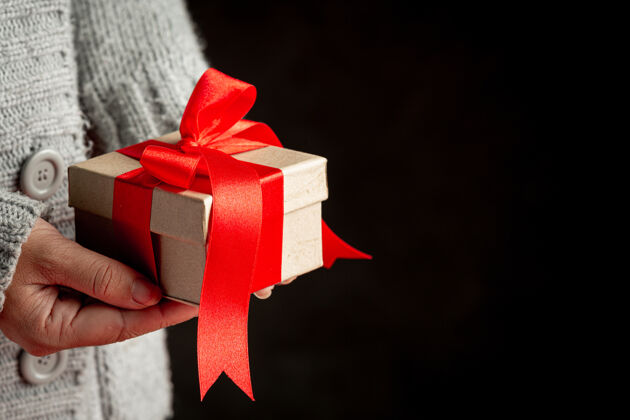 礼品盒女人手里拿着红丝带礼盒包装圣诞年