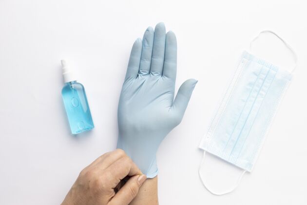 手套戴上带有洗手液和医用面罩的手套的手的顶视图平面预防疾病