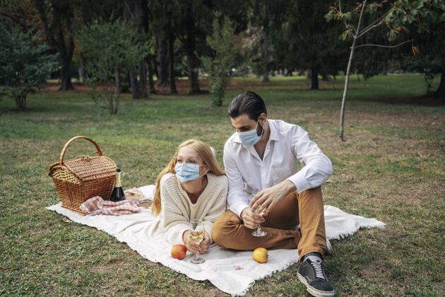 男人一对夫妇带着医用口罩野餐娱乐积极女人