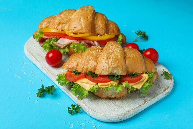 面包美味的概念吃羊角面包三明治蓝色 特写晚餐美食芝麻